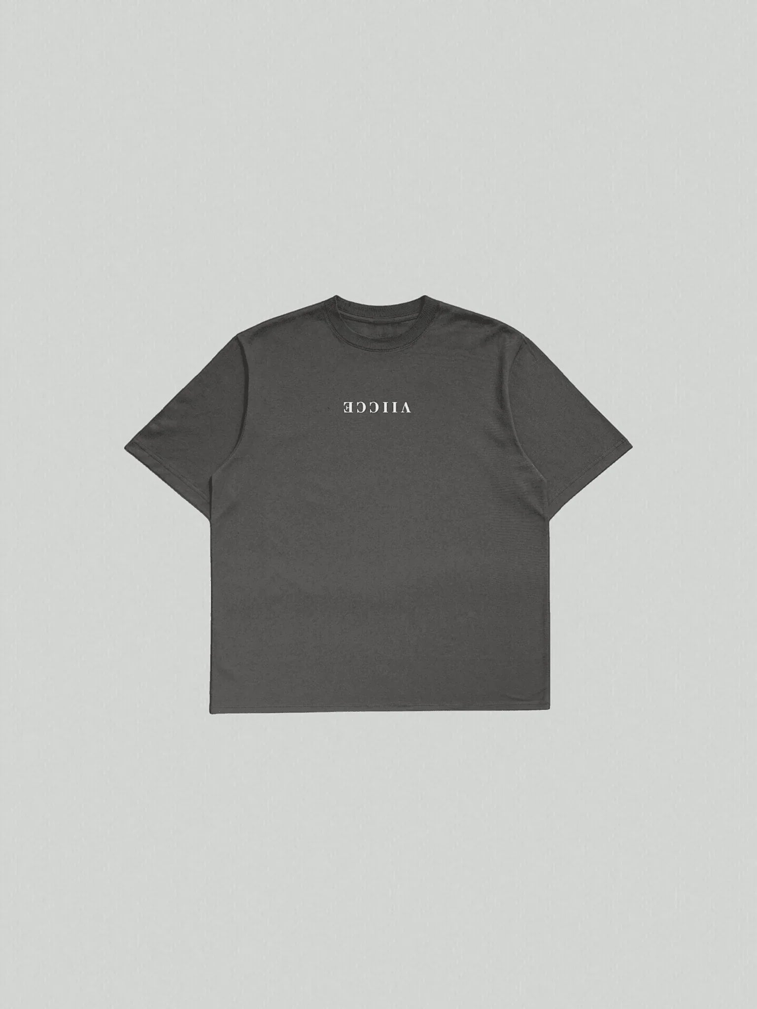Essence Tee - Vintage Black Oversized. T-shirt with a floor-lay design facing the front and "Viicce" written in reverse on the chest. Made with high-quality organic cotton. Studio photo.