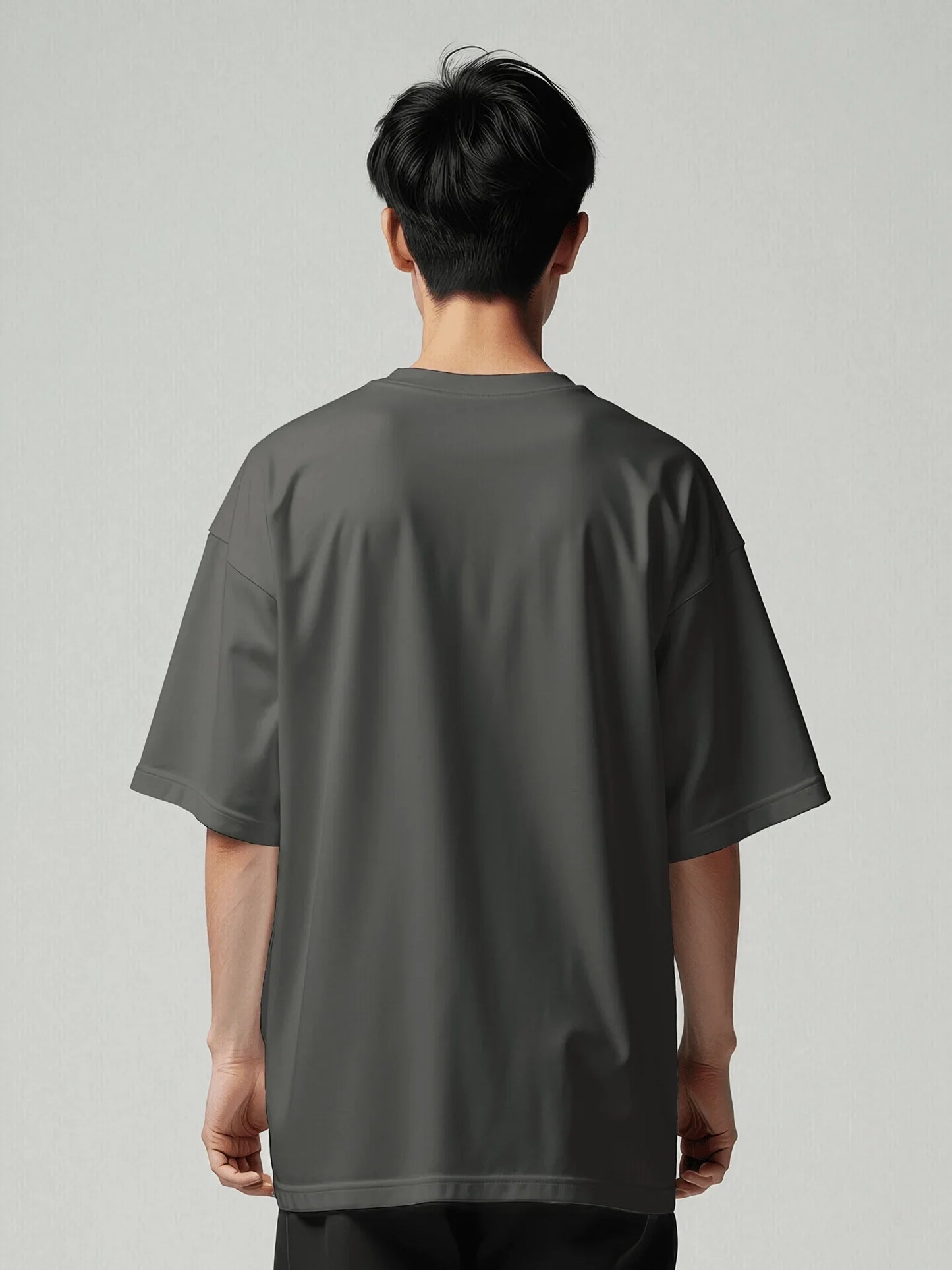 Essence Tee - Vintage Black Oversized. Back view of the model wearing an oversized t-shirt from Viicce. Made with high-quality organic cotton. Studio photo.