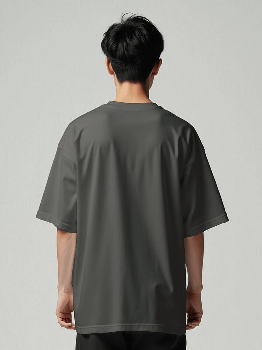 Essence Tee - Vintage Black Oversized. Back view of the model wearing an oversized t-shirt from Viicce. Made with high-quality organic cotton. Studio photo.