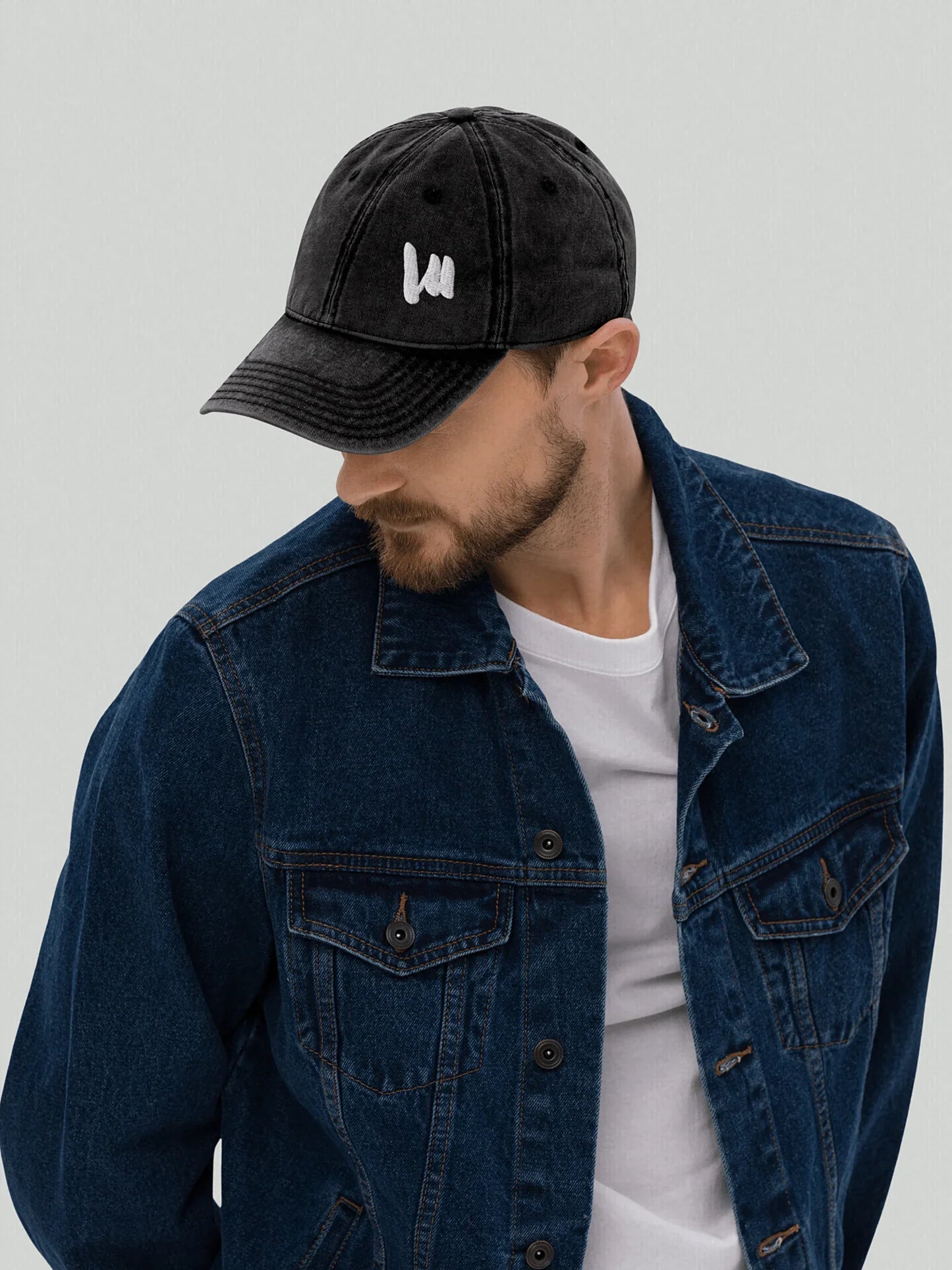 Male model wearing a black VIICCE vintage cap with an urban-style denim outfit