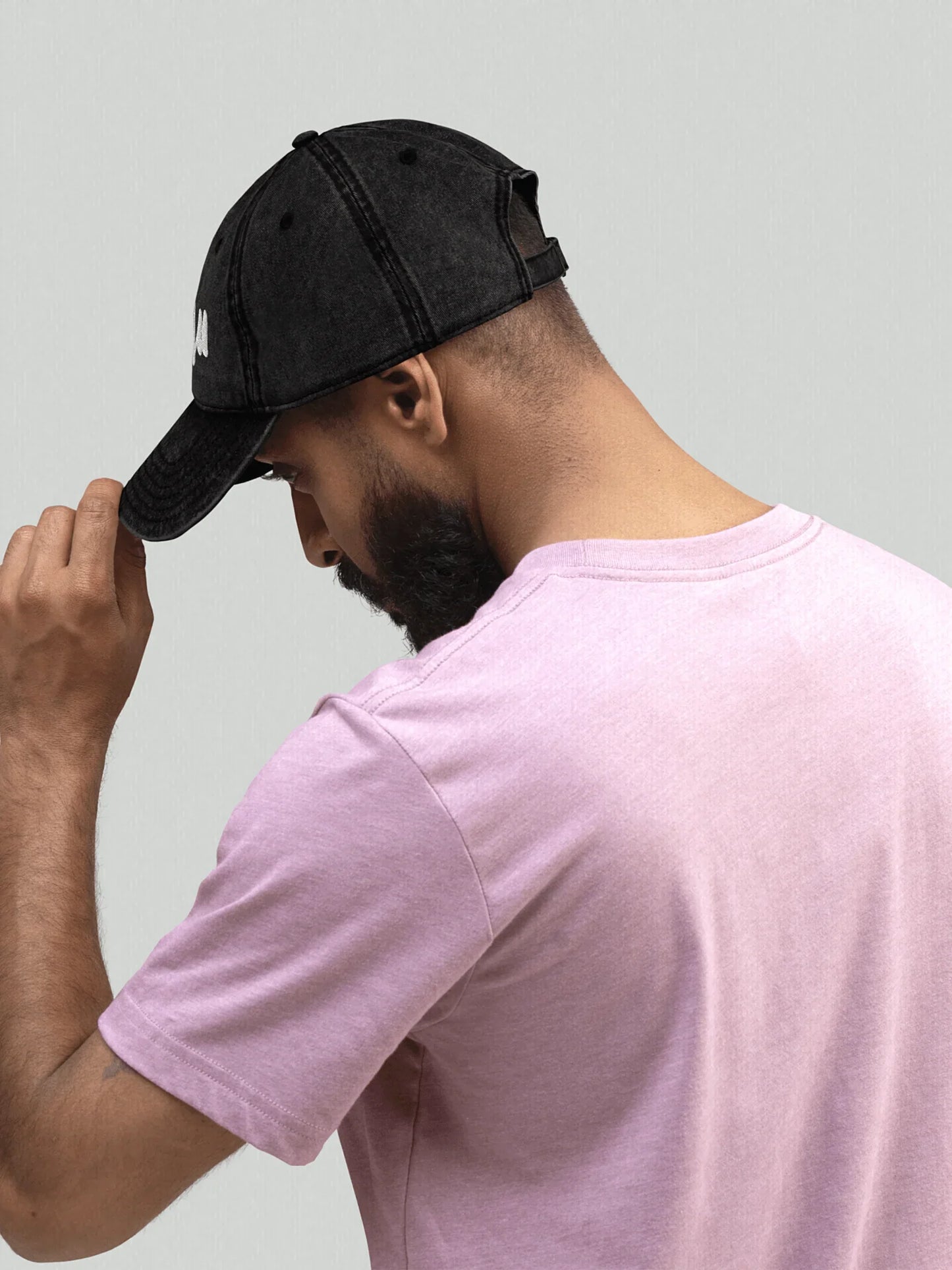 Model in side profile wearing a black VIICCE dad hat in a casual look