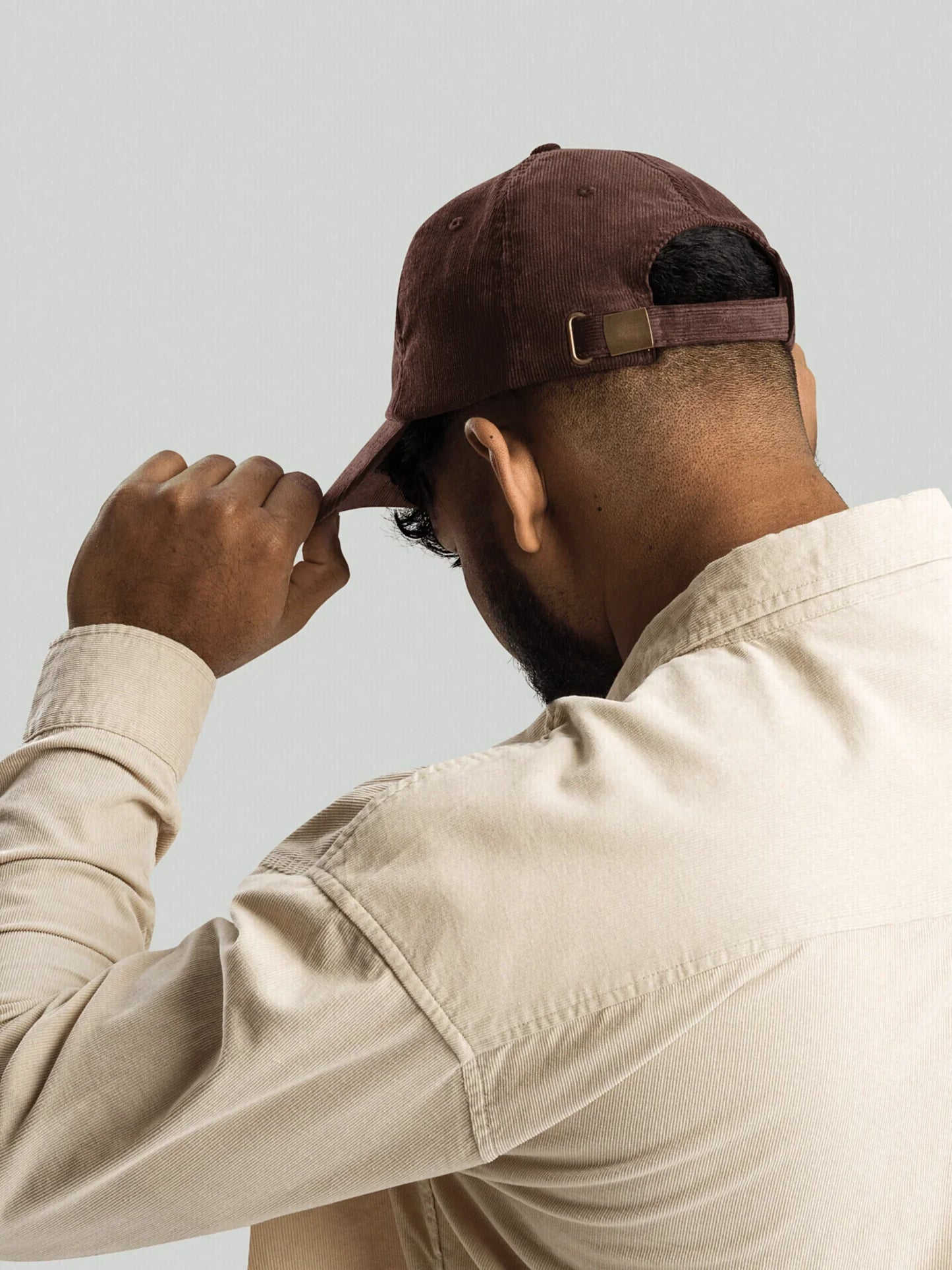 Men's model adjusting brown VIICCE cap, casual chic style