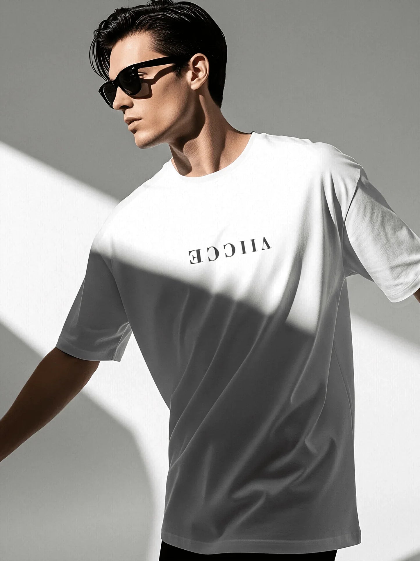 Origin Tee - Ash White Oversized. Front view of oversized ash-white T-shirt with viicce written upside down on the chest. Made from high-quality organic cotton. Studio photo.