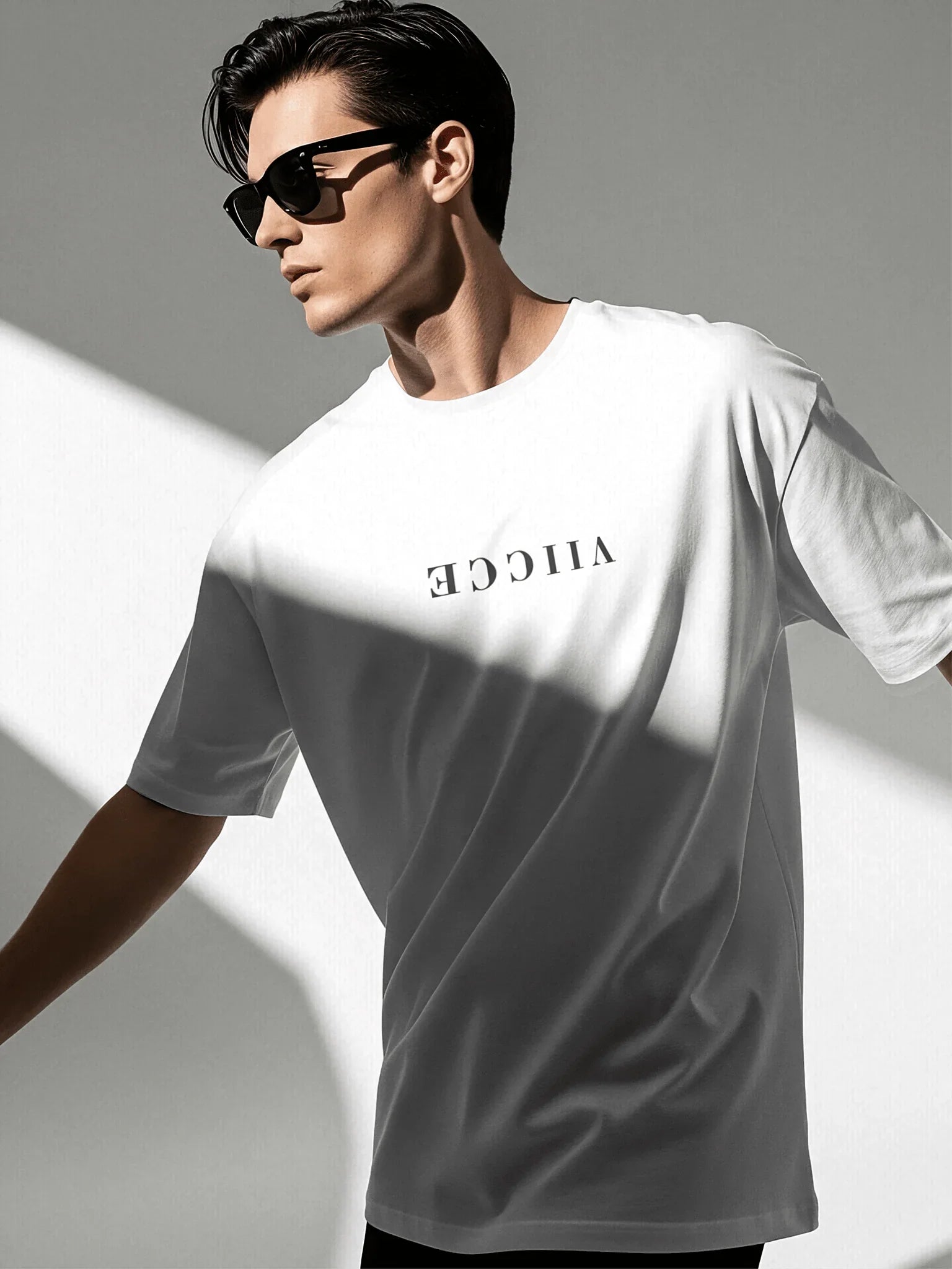 Origin Tee - Ash White Oversized. Front view of oversized ash-white T-shirt with viicce written upside down on the chest. Made from high-quality organic cotton. Studio photo.