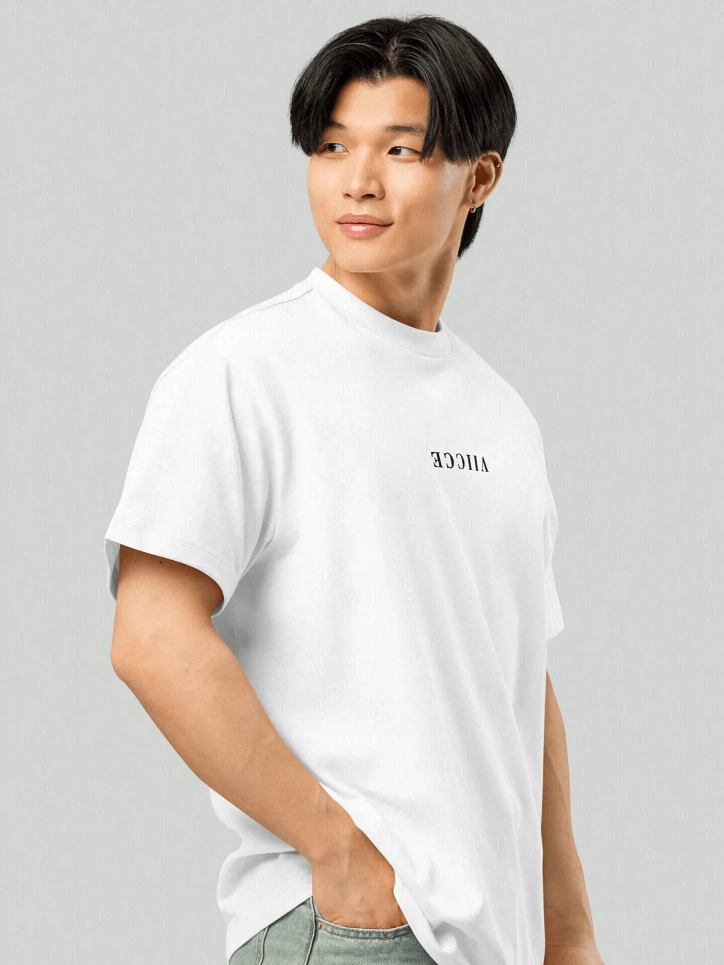 Origin Tee - Ash White Oversized. 
Front view image of model wearing oversized VIICCE T-shirt with inverted logo on chest. Studio image. Made from high-quality, heavyweight cotton (240 gsm).