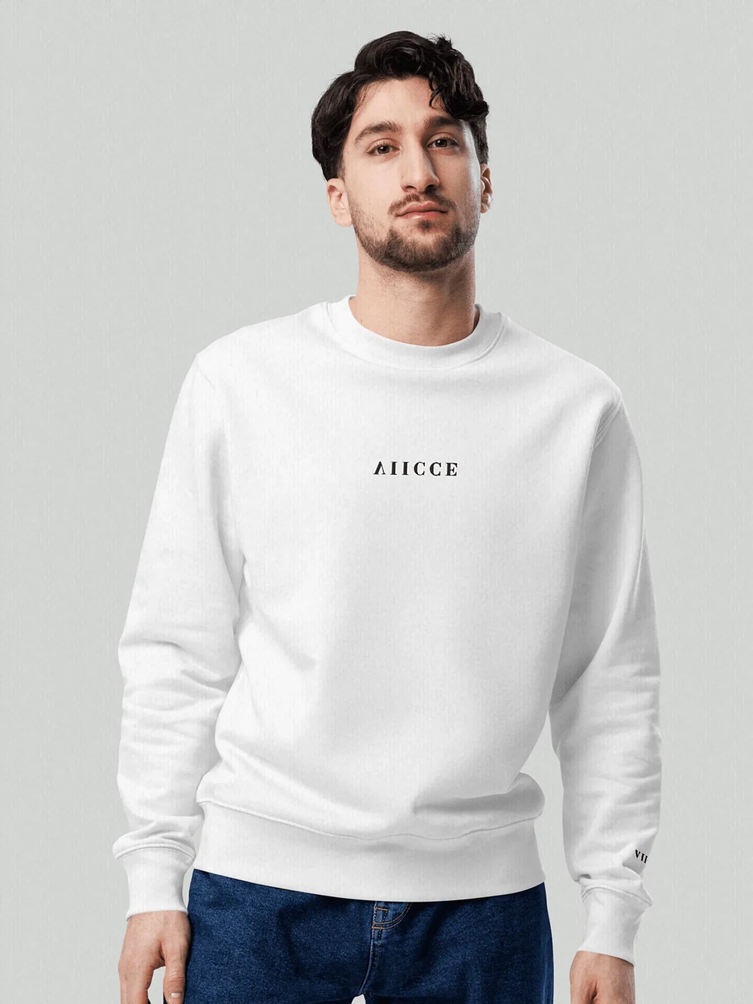 Signature Box Sweatshirt | Ash White.
Image of a male model facing the camera with a sweatshirt model from VIICCE, with VIICCE written in the chest vertically inverted. Studio photo. High quality cotton