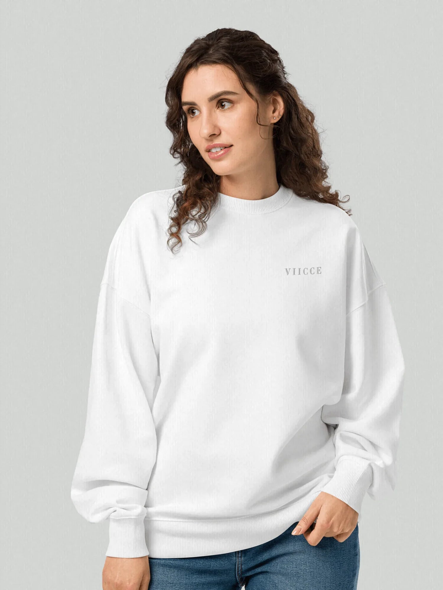 VIICCE Signature Sweatshirt in Bone White. Female model wearing an oversized boxy cut sweatshirt with a minimalist VIICCE logo printed on the left chest.