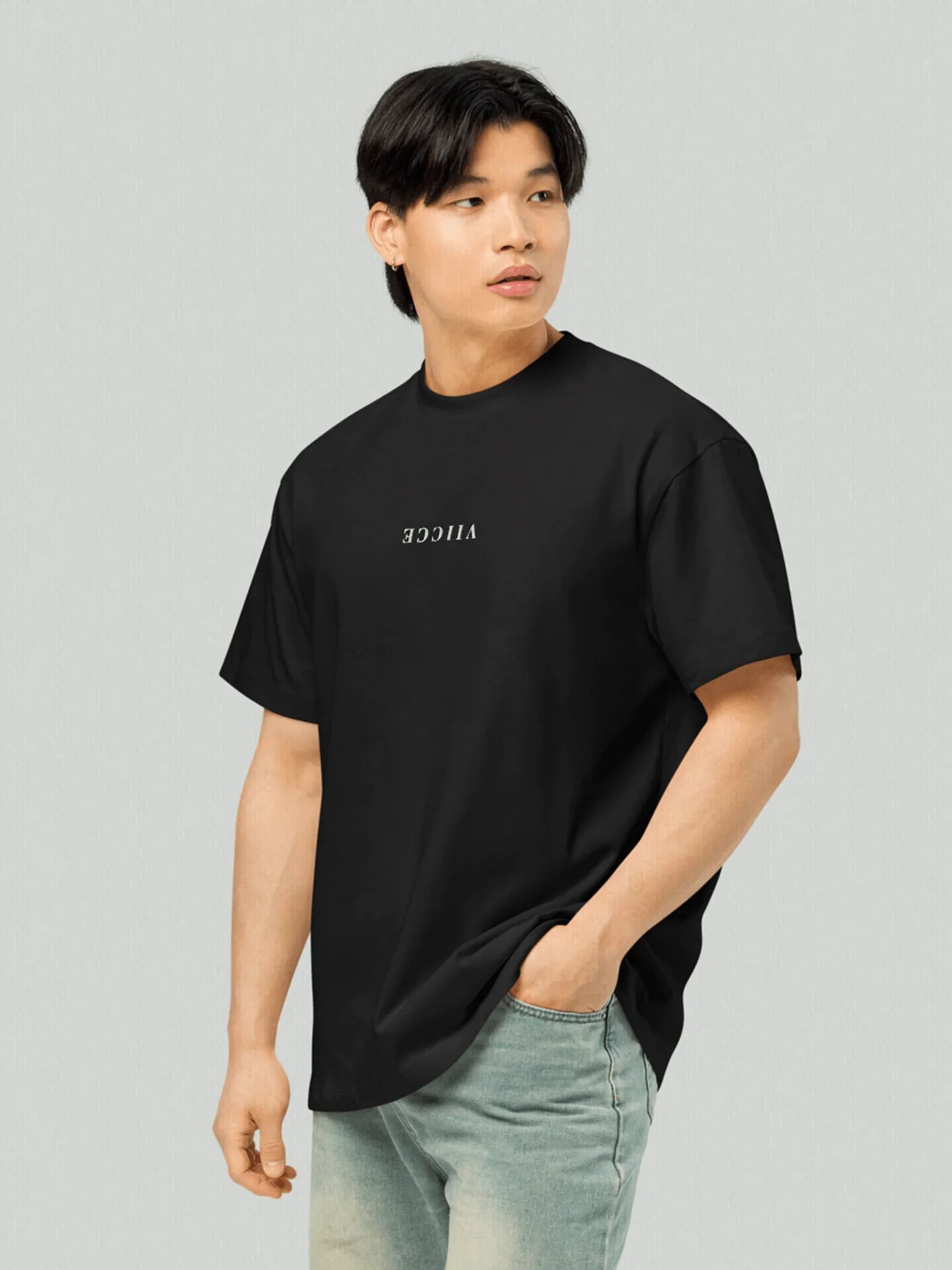 Signature Box Tee - Black Oversized. Image from a man 3/4 front, with a black oversized t shirt, written VIICCE vertically and horizontally inverted in the chest. Premium high quality cotton. Studio Image.