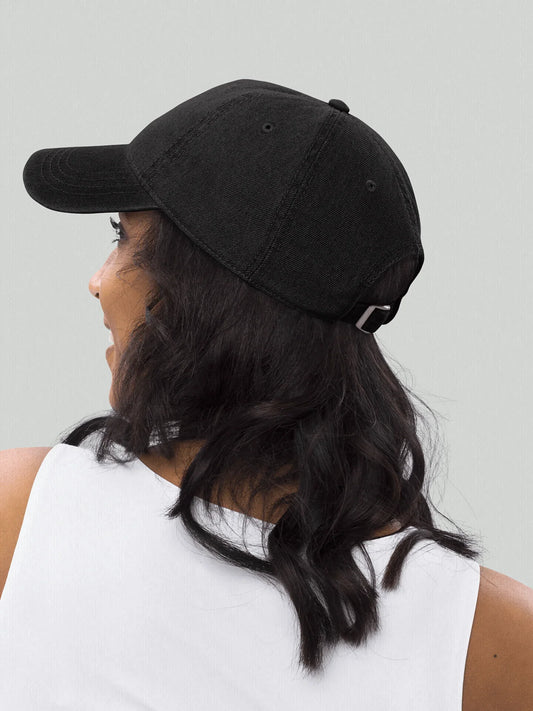 Female model seen from behind wearing a black VIICCE dad hat in streetwear style