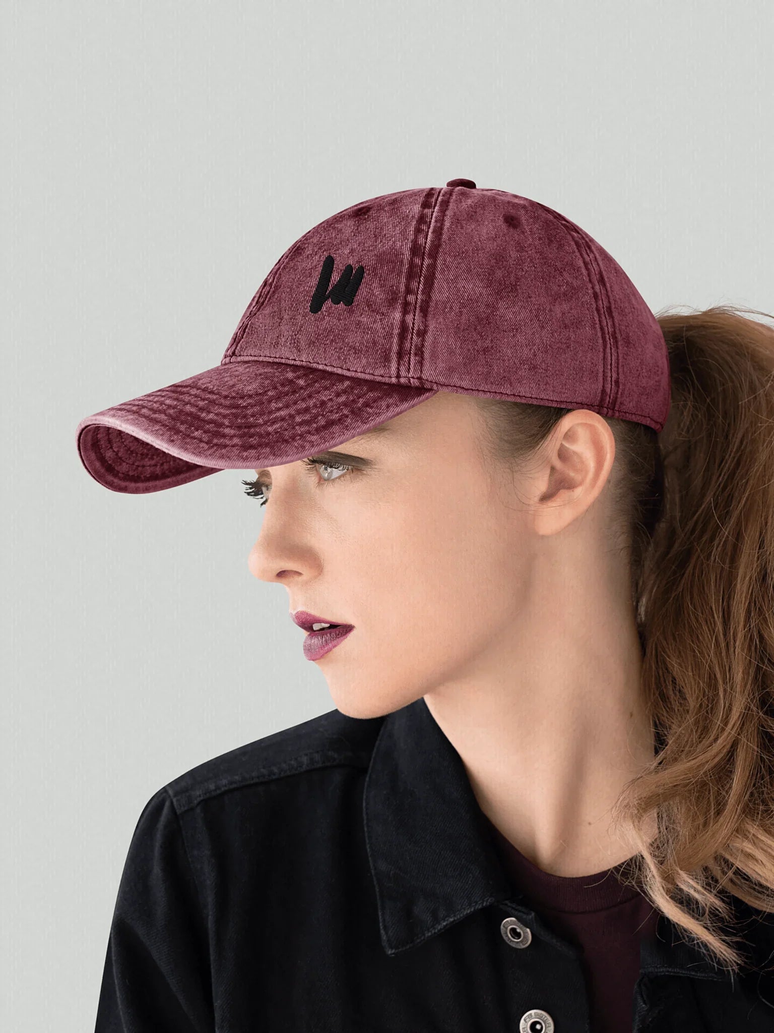 Female model wearing a burgundy vintage cap VIICCE side profile